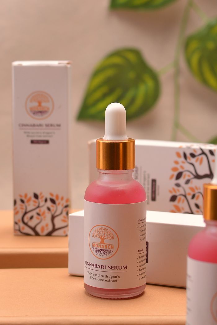 Services-03 Stylish presentation of Cinnabari serum bottles with vibrant packaging and a touch of greenery.